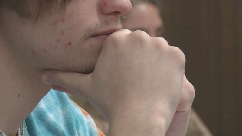 A student sits with his hands touching his face (Source: WVLT)