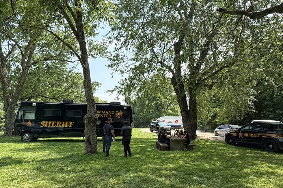 Officials stand at a staging area after an operation to recover multiple people who died while...